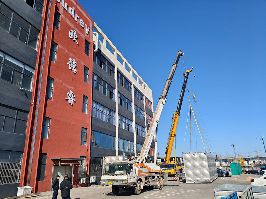 Crane installation of stainless steel water tanks customized for a Mexico client