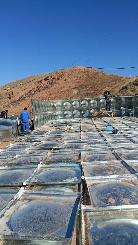 Industrial galvanized water storage tank for livestock drinking water supply and agricultural irrigation in rural mountain regions.